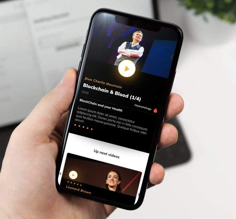 Mobile in hand, showing a video on its screen.