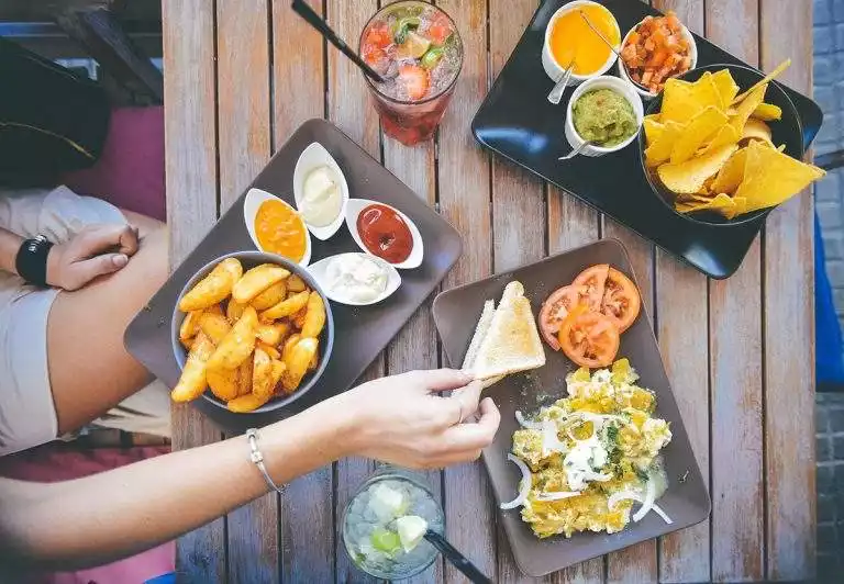 Image with three plates of food and two drinks.